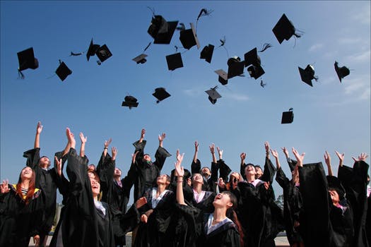 Students throwing their hats up at graduation near Center City Philadelphia apartments.